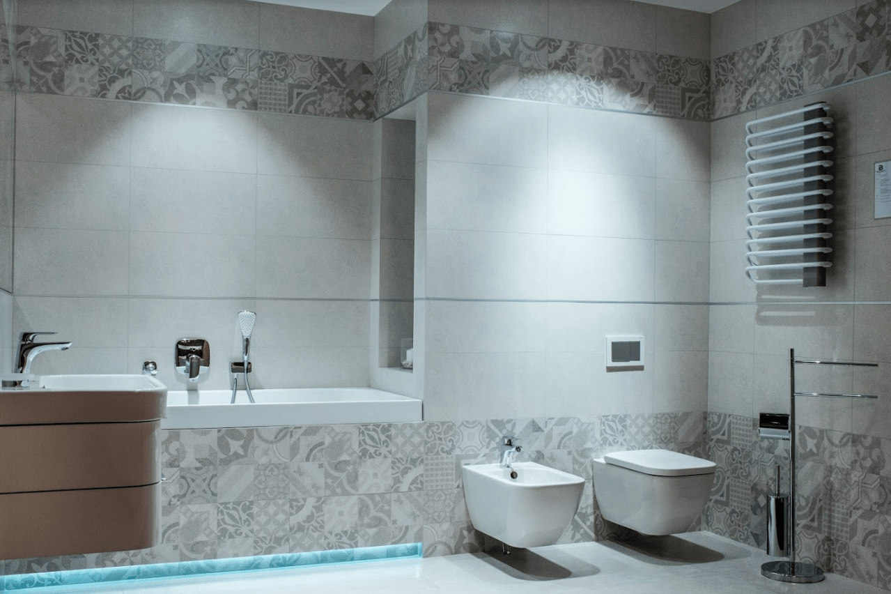 Wnętrze jasnej, białej łazienki z moizaiką w salonie w Piekarach Śląskich